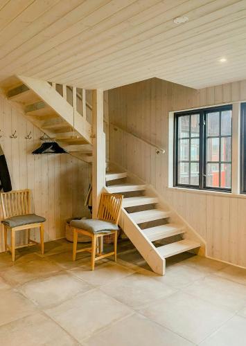 a staircase in a room with two chairs and a window at Active Holiday In Dalarnas Gopshus in Blyberg