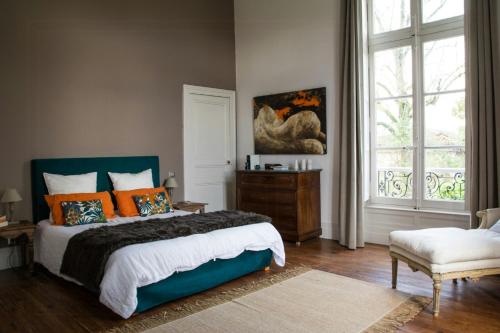 une chambre avec un lit avec des oreillers orange et une fenêtre dans l'établissement Charming Villa With Pool Near Toulouse, à Flourens