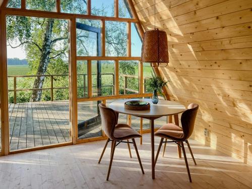 摩尔比兰加A-Frame Idyll On Öland With Magnificent Views的一间有桌椅和大窗户的餐厅
