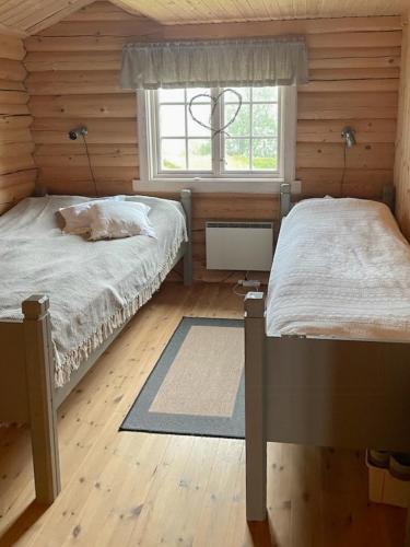 a bedroom with two twin beds and a window at Cozy, Magical Mountain Cabin With Trails in Etnedal