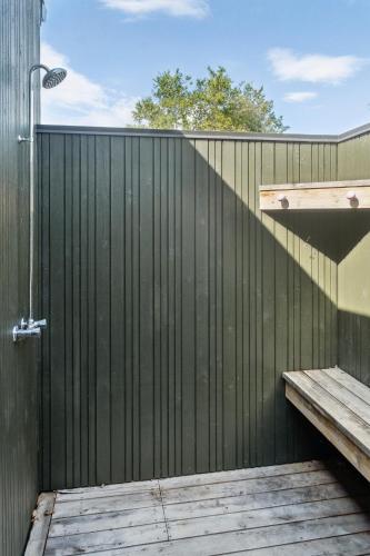 a wooden fence with a wooden bench on it at Moderne Familiesommerhus Ved Hav Og Aktiviteter in Nysted