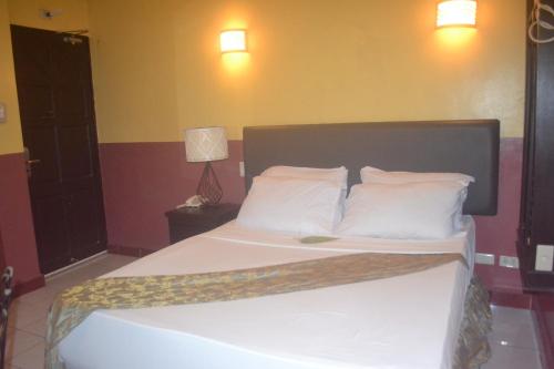 a bedroom with a bed with white sheets and pillows at DM Residente Hotel Inns & Villas in Angeles