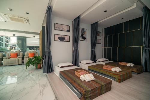 two beds in a room with a living room at Wekata Luxury in Kata Beach