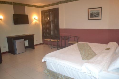 a hotel room with a bed and a table and chairs at DM Residente Hotel Inns & Villas in Angeles