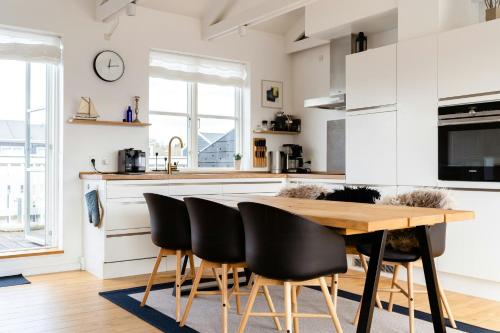 a kitchen with a wooden table and black chairs at Maritime Atmosphere In Holiday Island in Ebeltoft