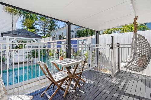 a patio with a table and chairs next to a pool at Azur Byron Bay in Byron Bay