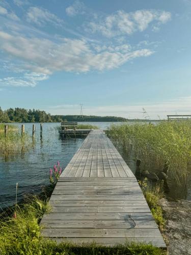 a wooden dock in the middle of a lake at Modern Mini-Villa With Lake View On Bryggholmen in Enköping