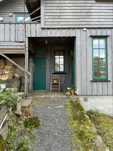 サンネフヨルにあるSeaside Cabin With Unique View And Designの緑の扉とポーチのある家