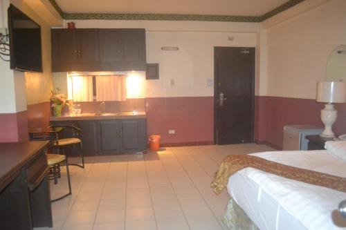 a kitchen and a bedroom with a bed and a kitchen at DM Residente Hotel Inns & Villas in Angeles
