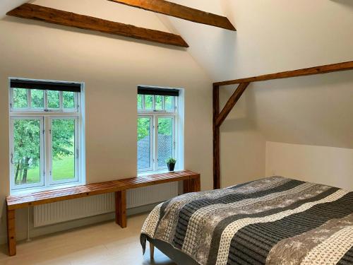 una camera da letto con un letto e due finestre di Historic Cottage By The Lake In South Jutland a Branderup
