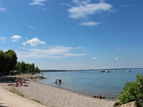 a beach with people swimming in the water at Holiday Home in Lazise near Lake Garda in Lazise