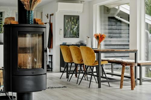 a living room with a wood stove and a table at Beautiful Tranquil Home By Fjord Near Copenhagen in Holbæk