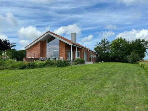 a brick house with a large lawn in front of it at Summer House With Panoramic View Near Doverodde in Doverodde