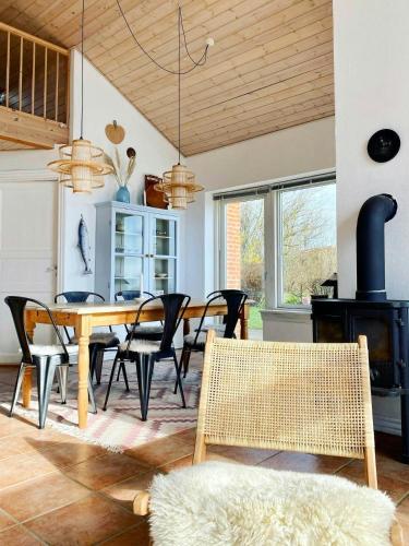 a dining room with a wooden table and chairs at Summer House With Panoramic View Near Doverodde in Doverodde