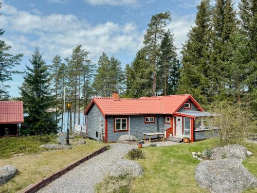 a small house with a red roof at Lakeside Holiday Home With Sauna Near Karlskoga in Karlskoga
