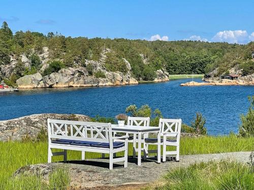 two benches sitting on a rock next to a lake at Irresistible Cabin Gem In Hvaler in Hauge