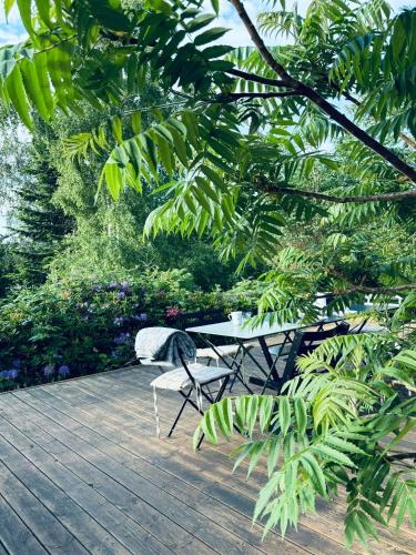 a table and chairs sitting on a wooden deck at Summer House On Hilltop Near Kikhavn Beach in Hundested