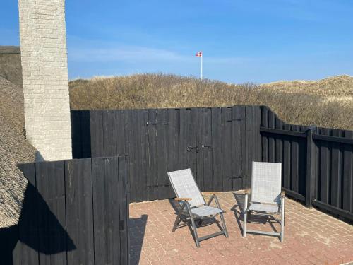two chairs and a fence on a patio at 13,000 Sqm Nature Plot Right Down To The Beach in Ringkøbing