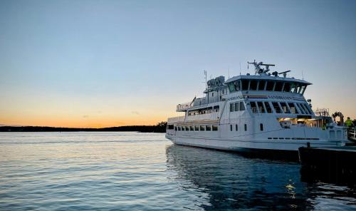 a ferry boat docked at a dock in the water at Archipelago With Dock Close To The Sea in Nämdö