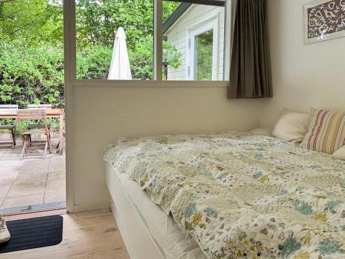 a bedroom with a bed and a view of a patio at Architectural Gem In Hornbæk Near The Beach in Hornbæk