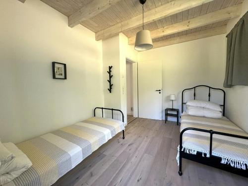 two beds in a room with wooden floors at Charming Forest House Near Lüneburg Heath in Handeloh