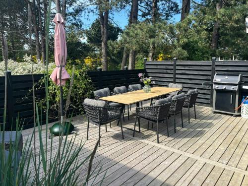 a wooden deck with a table and chairs and an umbrella at Holiday Home At Fynshoved in Martofte