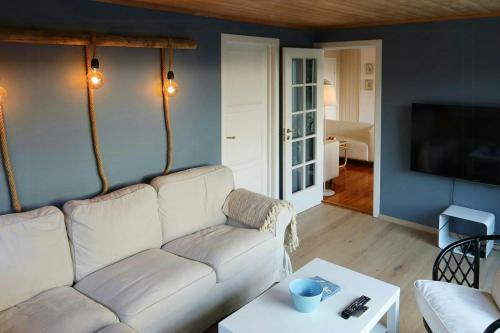 a living room with a white couch and a tv at Summer Cabin With Sea View In Southern Norway in Jordtveit