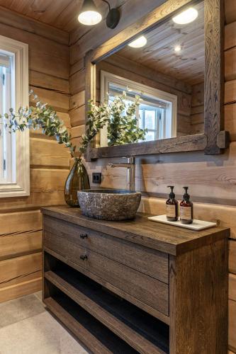 a bathroom with a sink and a mirror at Log Cabin Near Historic Senhovd in Veggli