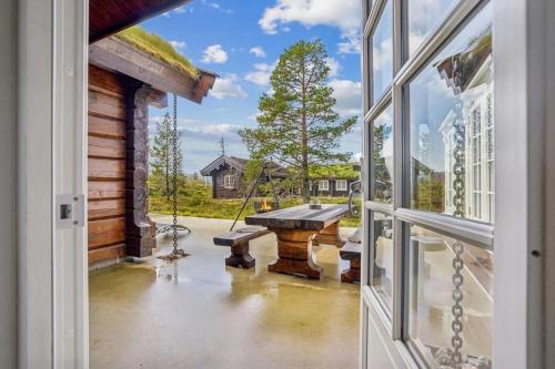 an open door to a porch with a picnic table at Log Cabin Near Historic Senhovd in Veggli