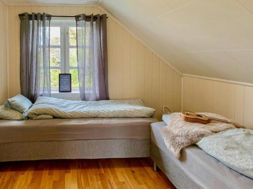 Dos camas en una habitación con ventana. en Red Cottage By The Sea In Laukvika, en Laukvik