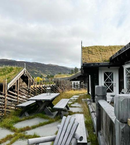 a picnic table and a building with a grass roof at Luxury Log Cabin By Hardangervidda in Uvdal