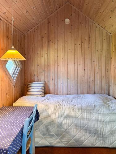 a bedroom with a bed in a wooden room at Architect-Designed Summer House Near Hald Strand in Liseleje