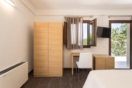 a bedroom with a bed and a desk and a window at Giardino Sul Duomo in Ragusa