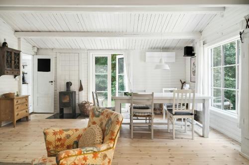 een woonkamer met een eettafel en stoelen bij Classic 1937 Cottage On A Natural Plot in Nykøbing Sjælland