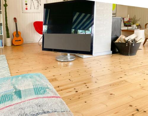 a living room with a large flat screen tv on a wooden floor at House Near Woods And Fields In Mols Bjerge in Kolind