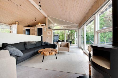 a living room with a couch and a table at Summer House With Terrace Overlooking Nature in Tikøb