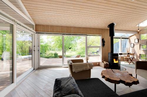 a living room with a couch and a table at Summer House With Terrace Overlooking Nature in Tikøb
