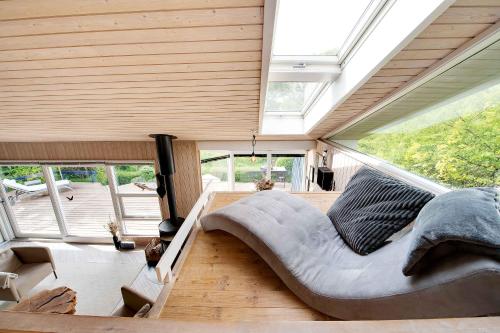 a large bed in a room with a large window at Summer House With Terrace Overlooking Nature in Tikøb