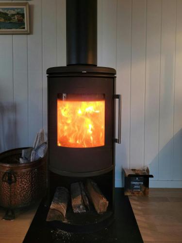 a stove with a fire inside of it at Modern Captains House On Beautiful Skåtøy in Kragerø