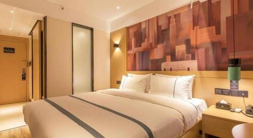 a bedroom with a large white bed in a room at City Comfort Inn Wuhan International Expo Center Yongwang in Wuhan