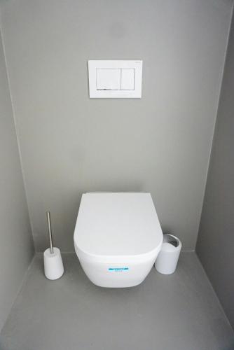 a white toilet in a bathroom with two rolls of toilet paper at Minimalist Style Apartment In Upper Palatinate in Neunburg vorm Wald