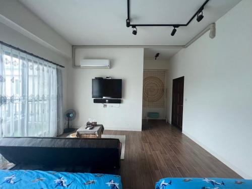a living room with a couch and a tv on the wall at Come Home Travel in Tainan