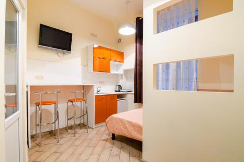 リヴィウにあるEconomy Apartment on Rappoporta 7a-1の小さな客室で、キッチン(オレンジ色のキャビネット付)が備わります。
