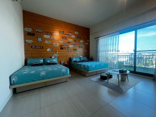 a bedroom with two beds and a large window at Come Home Travel in Tainan