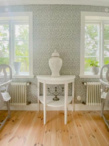 a white table with a vase on it in a room at Countryside Farm With Pool In Västergötland in Ljung