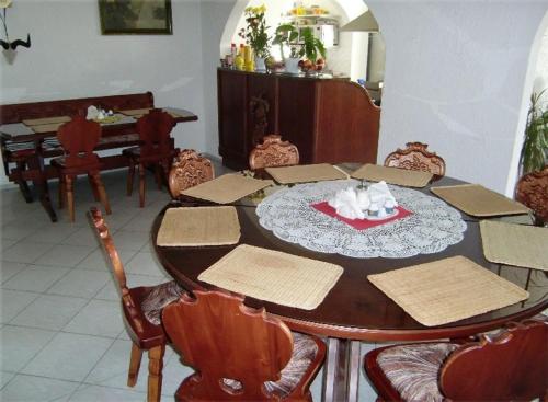 uma sala de jantar com uma mesa de madeira e cadeiras em Penzion Buchmann em Františkovy Lázně