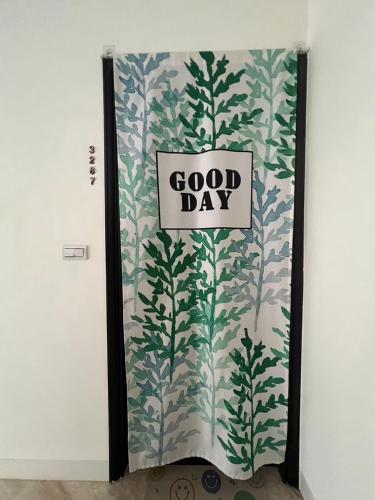 a door with a good day sign on a wall at Come Home Travel in Tainan