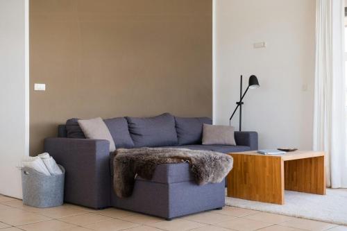 a living room with a blue couch and a table at West Jutland In Peaceful Havblik Setting in Nørlev