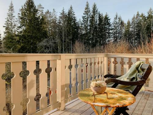 a wooden balcony with a table and a chair at Restored Quarry House Near Nobel Laureate Home in Lönsboda