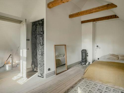 Un dormitorio con una cama y un espejo en la pared. en Unique Mission House By Lake Sommen, en Hult